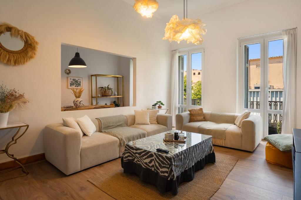 a living room with two couches and a coffee table at Dimora - A Spacious Luxury Penthouse in Town's Heart in Corfu Town