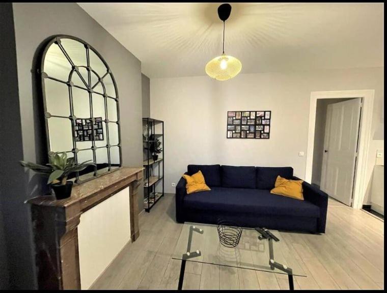 un salon avec un canapé bleu et une cheminée dans l'établissement Boulard - 2ème étage Ancien, à Reims