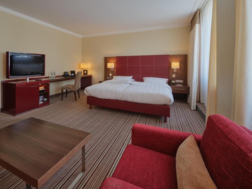 a hotel room with a bed and a couch at Steigenberger Graf Zeppelin in Stuttgart