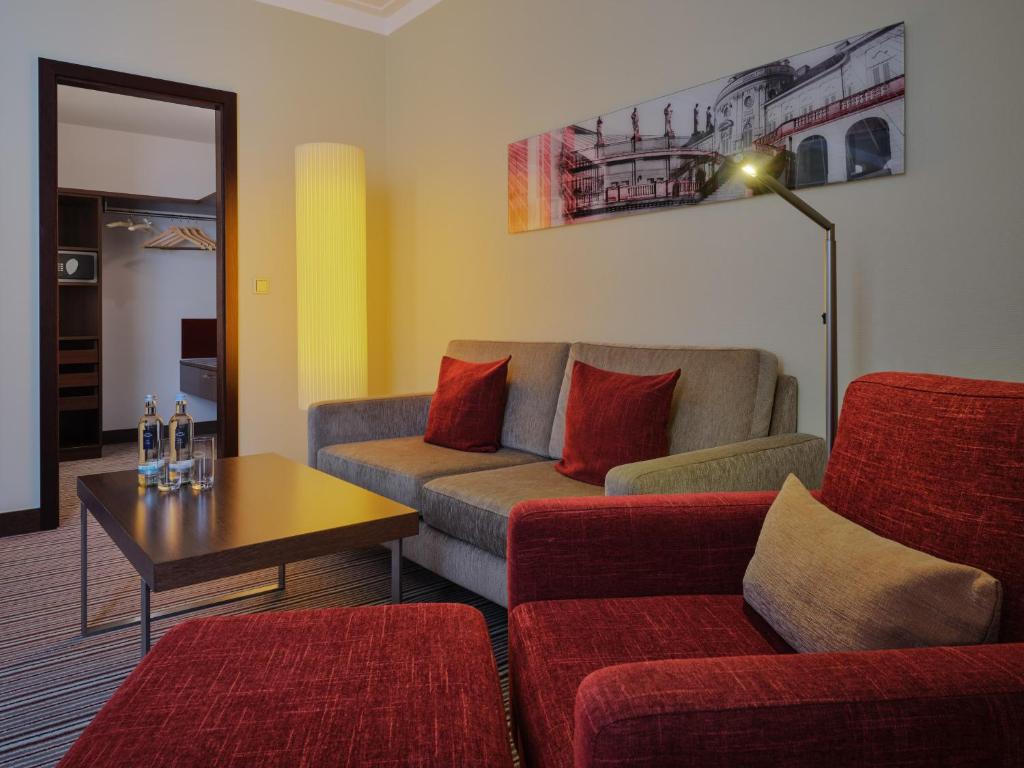 a living room with a couch and a table at Steigenberger Graf Zeppelin in Stuttgart