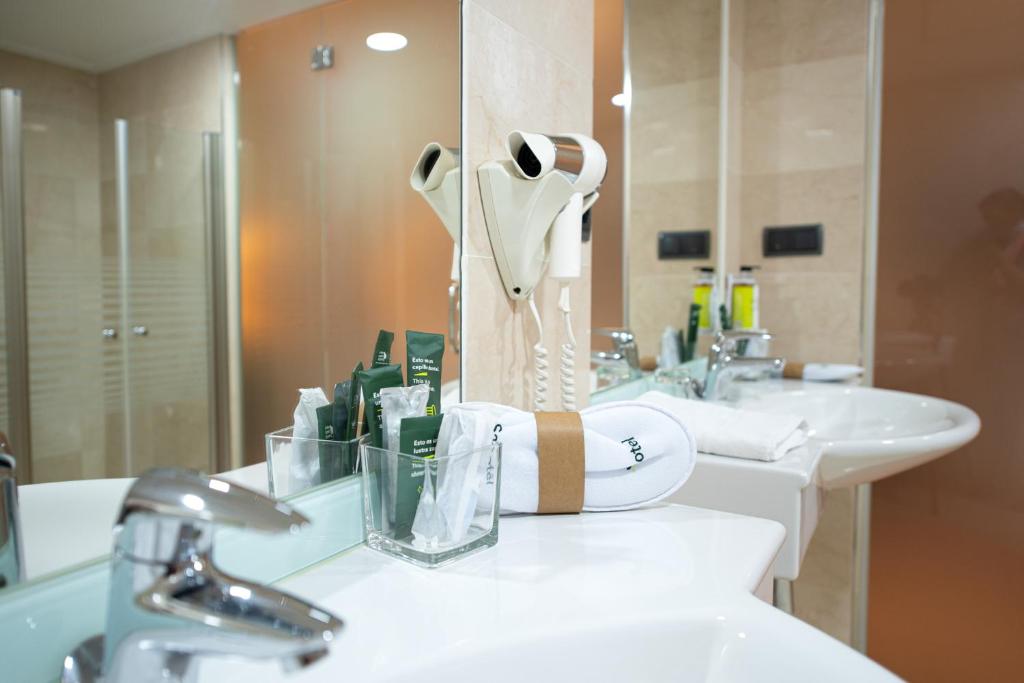 a bathroom with two sinks and a mirror at Sercotel Riscal in Puerto Lumbreras