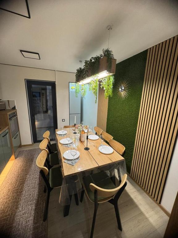 a dining room with a long table and chairs at KUZINATRA Apartament in Slănic-Moldova