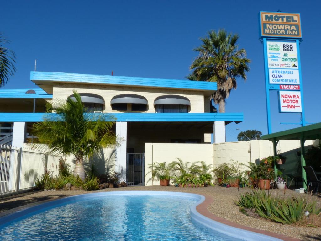 a hotel with a swimming pool in front of a building at Nowra Motor Inn in Nowra