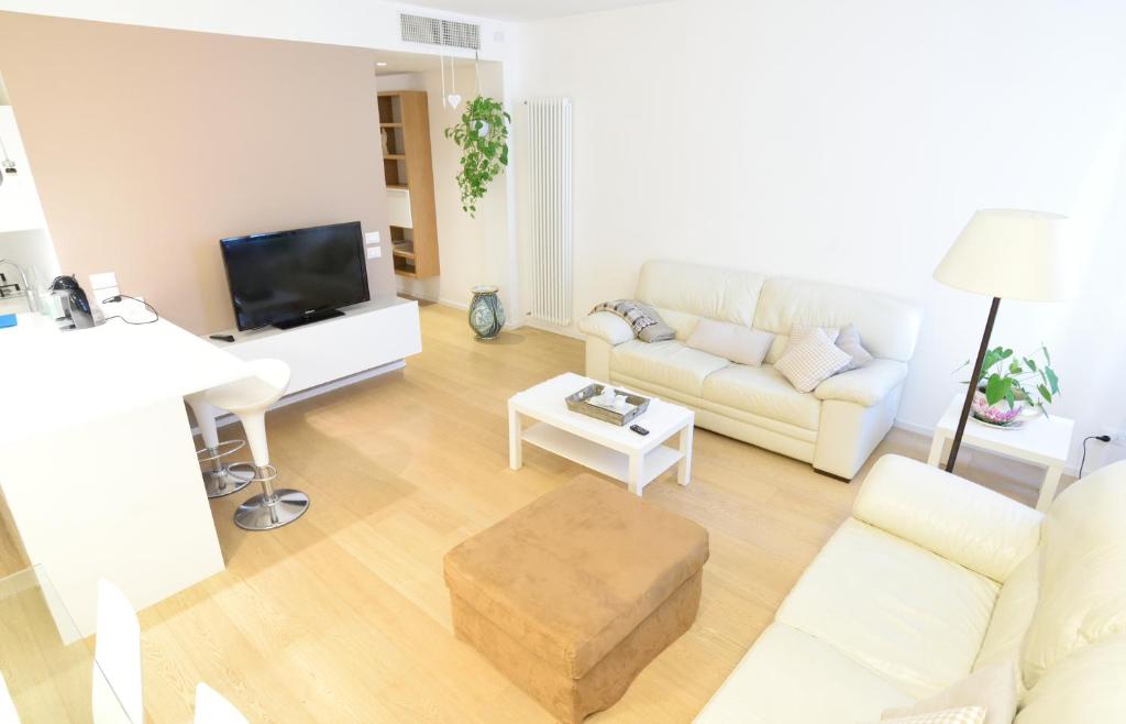uma sala de estar com um sofá branco e uma televisão em Al Campanile em Veneza