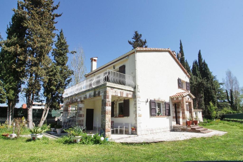 une grande maison blanche dans un champ arboré dans l'établissement Ma Vie, à Mandelieu-la-Napoule
