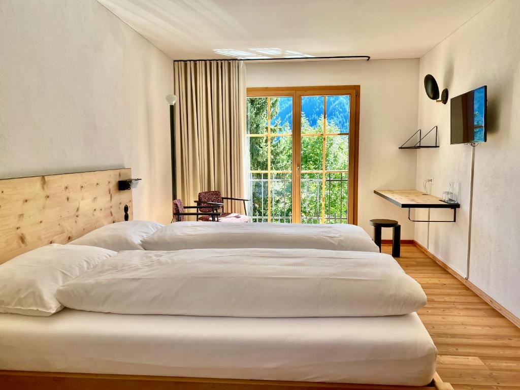 una camera con tre letti e una grande finestra di Hotel Central La Fainera Superior a Valchava