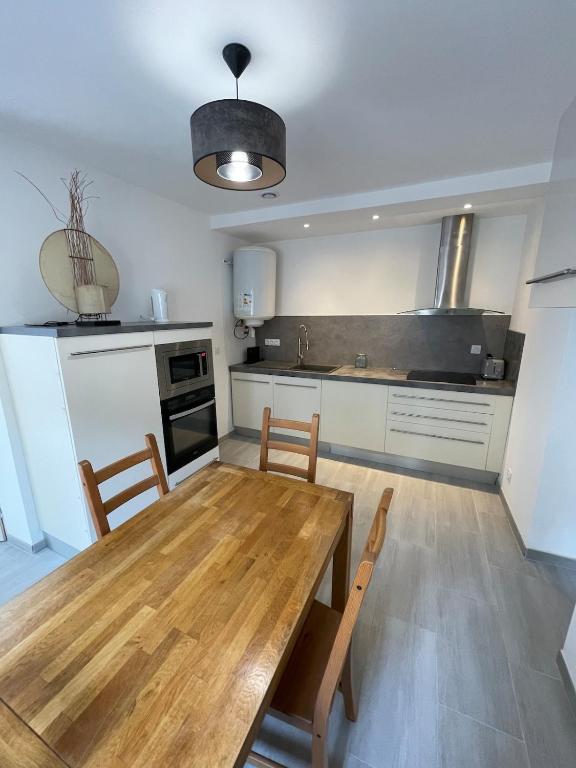 une cuisine avec une table et des chaises en bois dans l'établissement Chez Franou, centre ville , rez de chaussée, à Nîmes