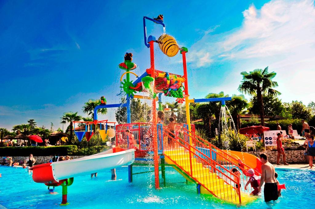 a water park with a water slide in the water at Camping Bella Italia in Peschiera del Garda