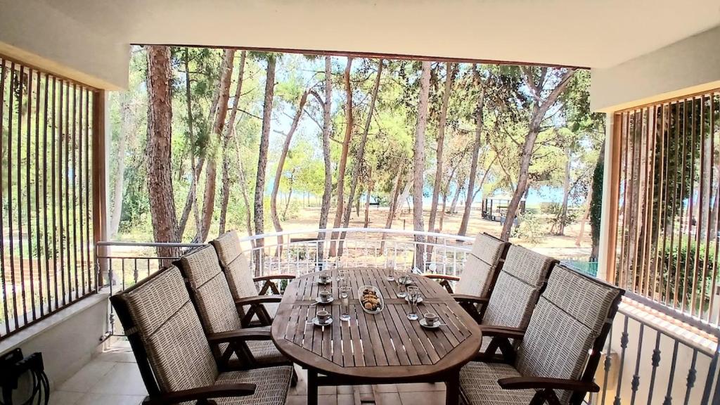 a wooden table and chairs on a balcony at Villa Irida in Nea Makri
