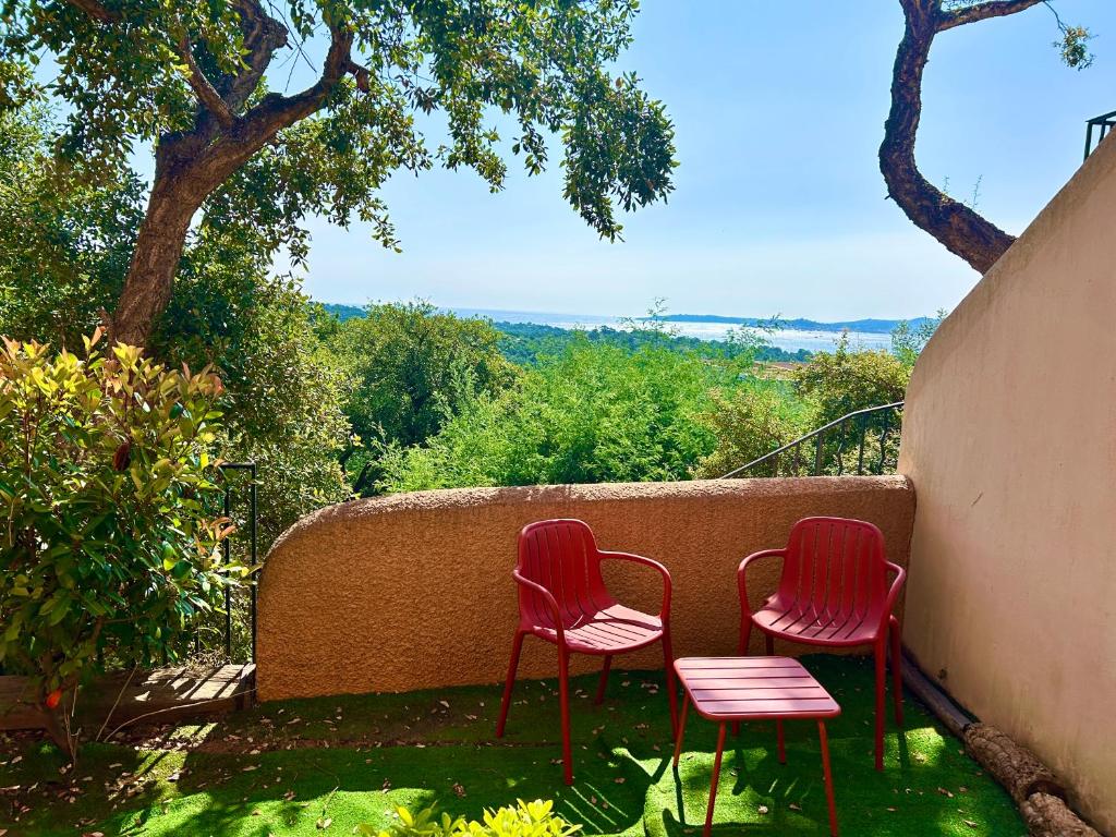 due sedie rosse sedute accanto a un muro di Les Restanques vue mer Freesia a Grimaud