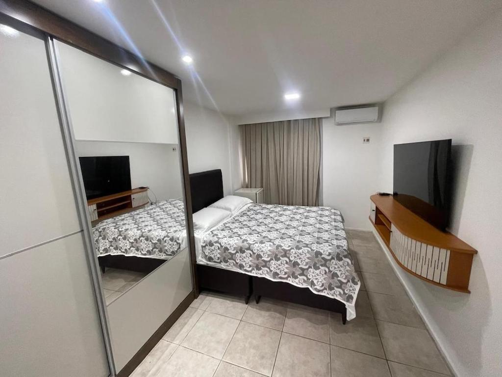 a small bedroom with a bed and a mirror at Flat Acolhedor e Familiar in Fortaleza