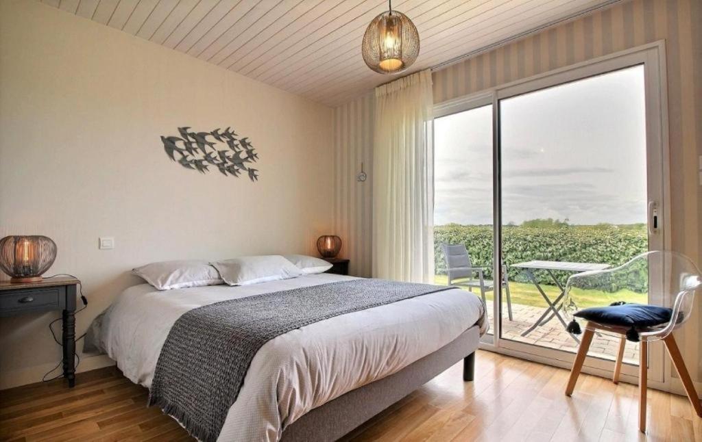 une chambre avec un lit et une grande fenêtre dans l'établissement Gite de Kertanguy entre terre et mer, à Mespaul