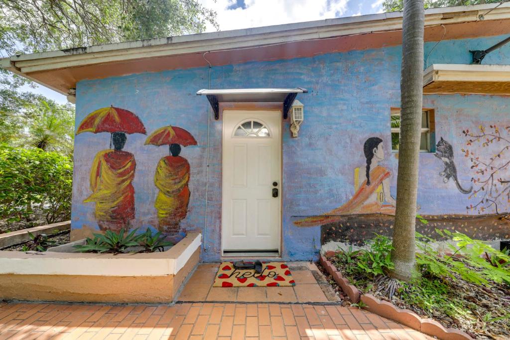 a house with a painting of people with umbrellas on it at 5 Mi to Surfside Beach Peaceful Miami Bungalow! in Miami