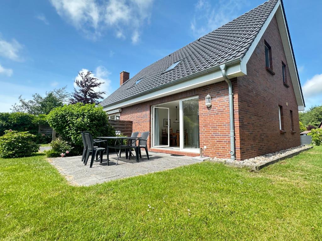 a house with a table and chairs in the yard at Haus Eismöwe in Böhl