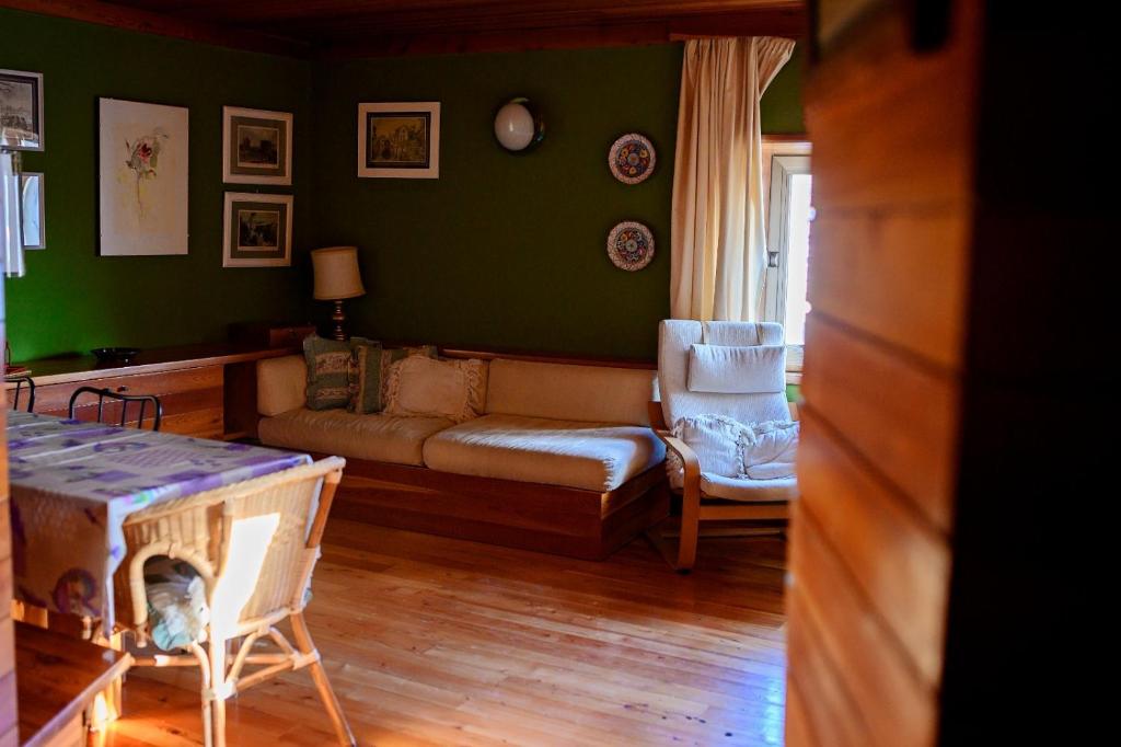 un soggiorno con un divano e una poltrona di Casa in centro storico stile chalet di montagna a Ovindoli