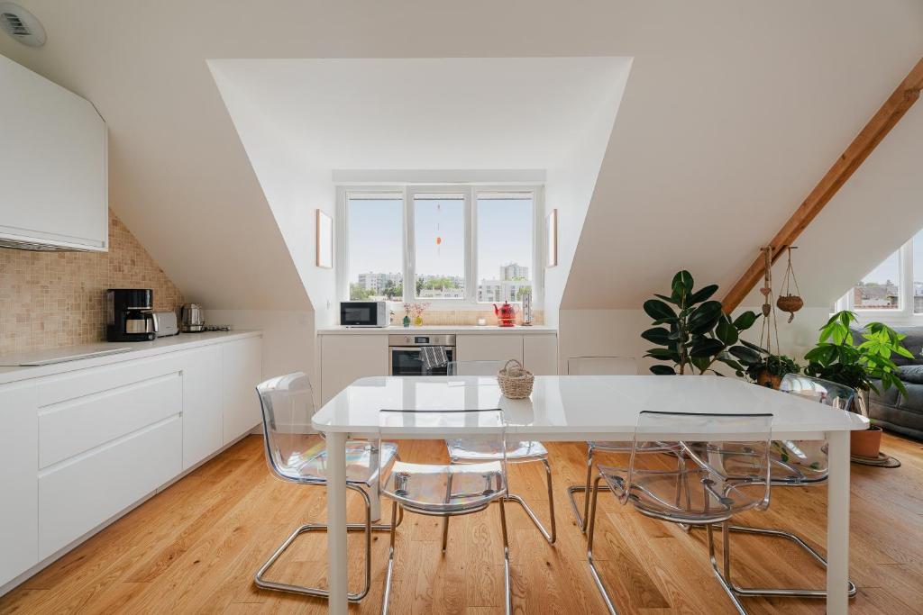 una cucina bianca con tavolo e sedie bianchi di Logement calme proche centre ville a Rennes