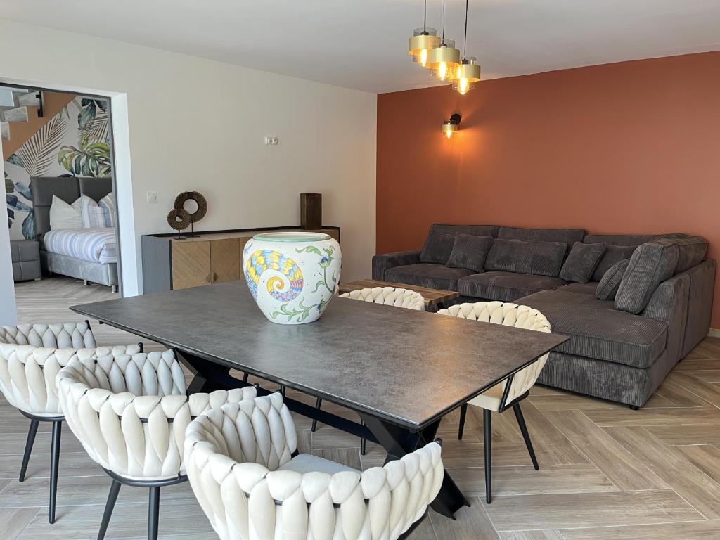 een woonkamer met een tafel met stoelen en een bank bij La Petite Saulaie - Proche circuit 24h - 6 pers in Changé