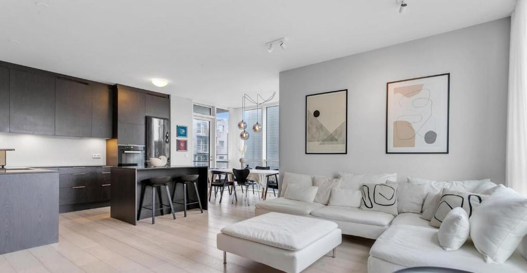 Una sala de estar con un sofá blanco y una cocina. en Stylish stay in downtown Rvk, en Reikiavik