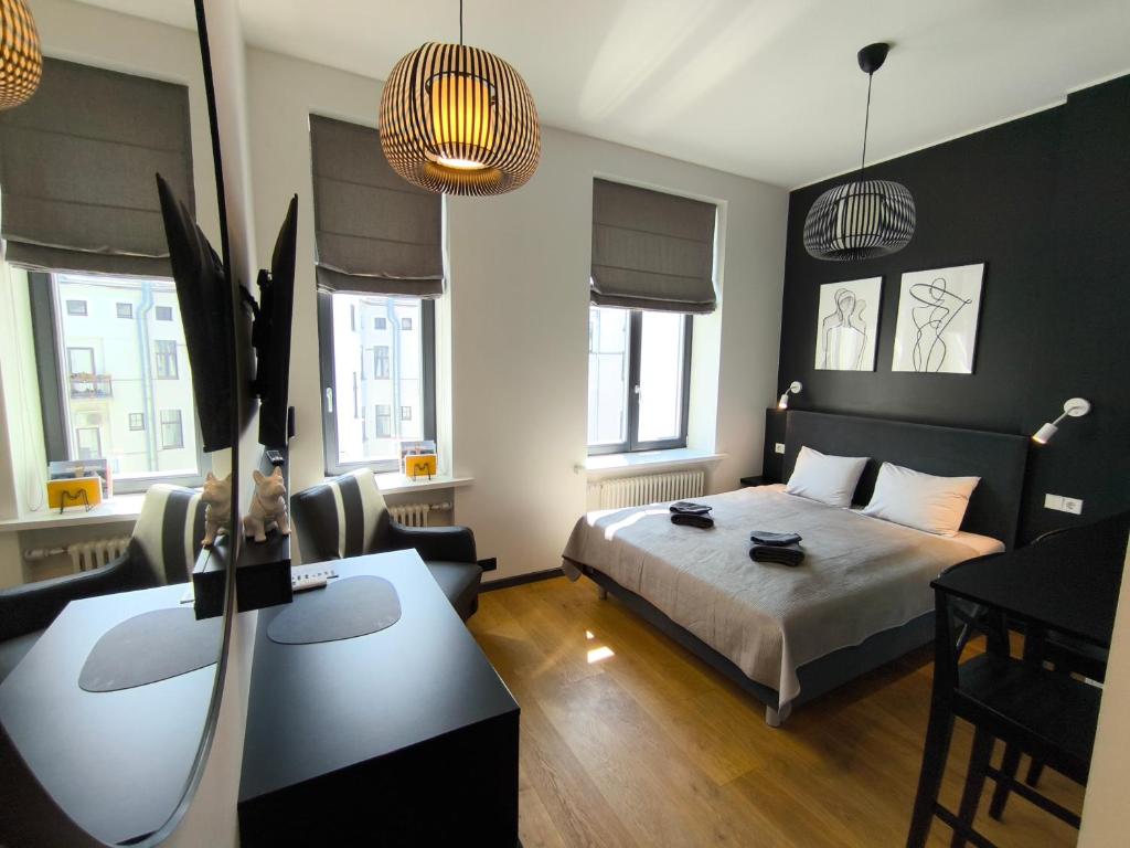 a bedroom with a bed and a desk in it at Albert Studio in Art Nouveau building with AC Top location near old town in Rīga