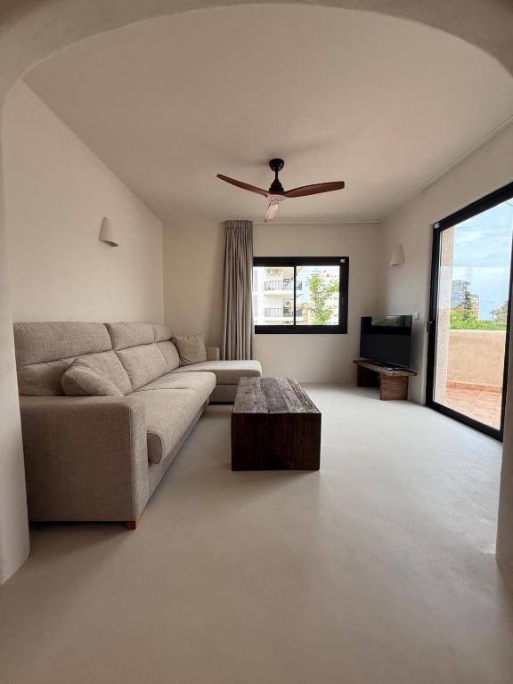 a living room with a couch and a ceiling fan at Casa Bel - Apartment 2 in Miami Platja