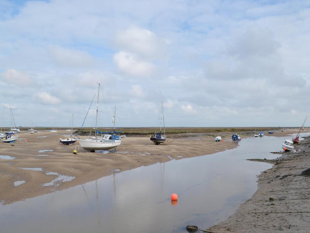 a group of boats parked on the beach at Wherry Cottage in Wells next the Sea