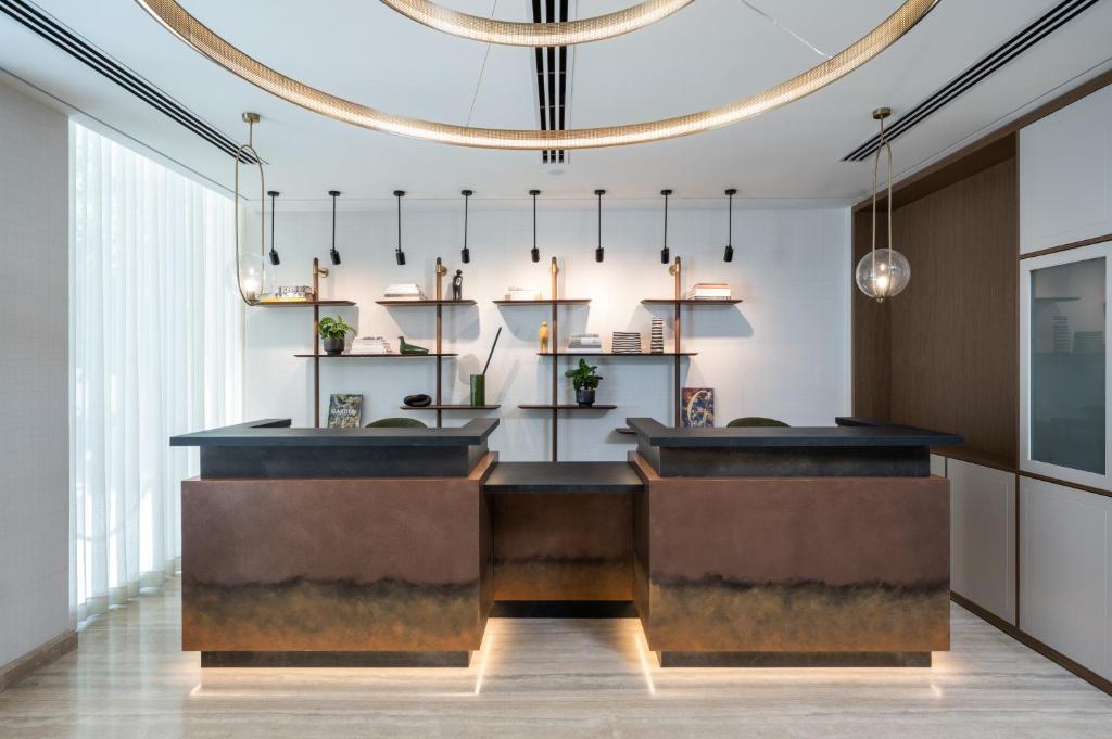 un bar dans un restaurant orné d'un lustre dans l'établissement Hotel Nucha-Fattal Colors, à Jérusalem