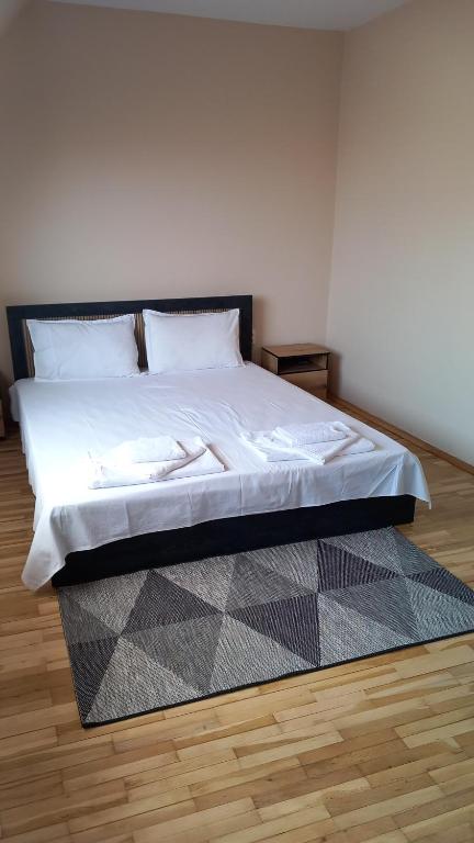 a bedroom with a large bed with white sheets at Апартамент Плажен рай in Burgas City