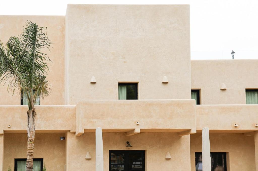 a building with a palm tree in front of it at Casa Bel - Apartment 5 in Miami Platja