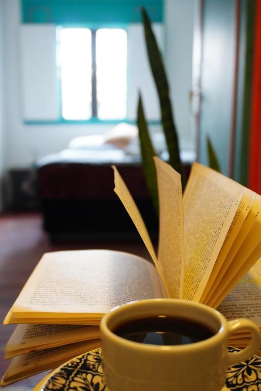 a cup of coffee and a book on a table at Kimaná Hostal in Santa Rosa de Cabal