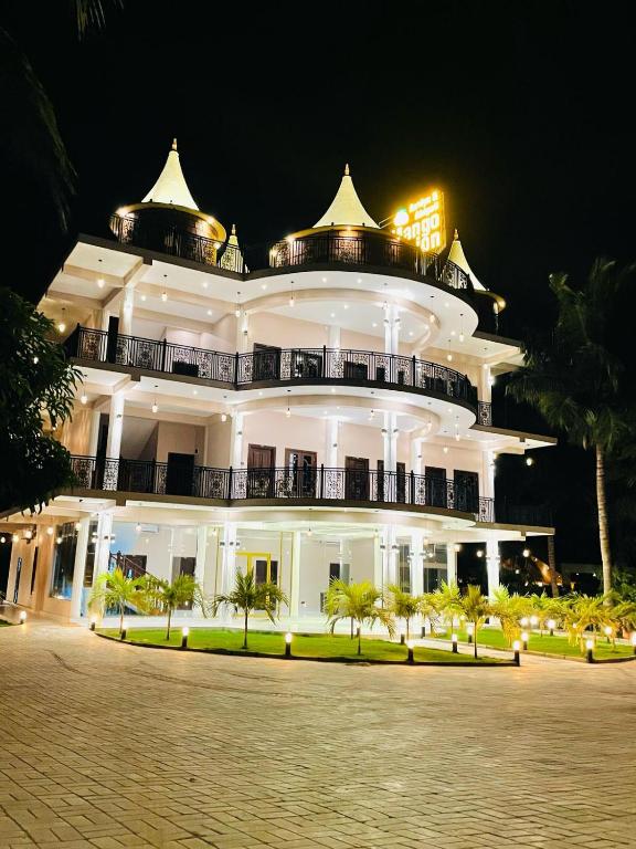 Un gran edificio blanco por la noche con palmeras al frente. en Mango Mansion, en Jaffna