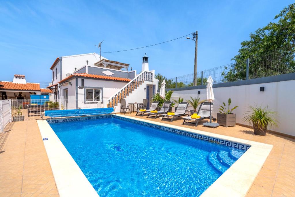 a swimming pool in front of a house at Vila da Encosta - Private - Heated swimming pool - By bedzy in Albufeira