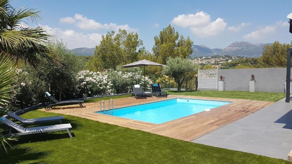 - une piscine dans une cour avec 2 chaises et un parasol dans l'établissement VILLA Loakel, à La Gaude
