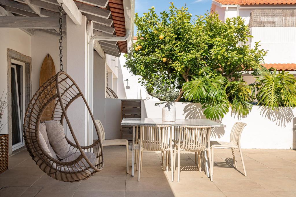 a patio with a table and chairs and a swing at Sea'Ya Thoughtful Stays - Villas in Cascais
