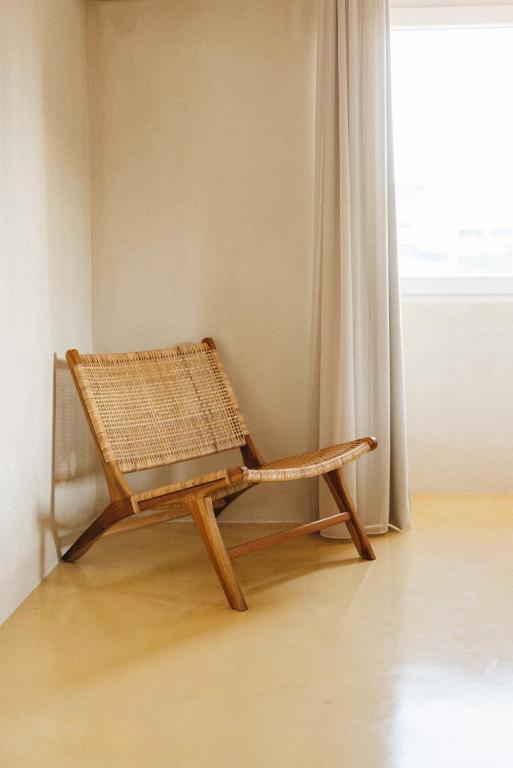 a rattan bench sitting in a room with a window at Sea'Ya Thoughtful Stays - Villas in Cascais
