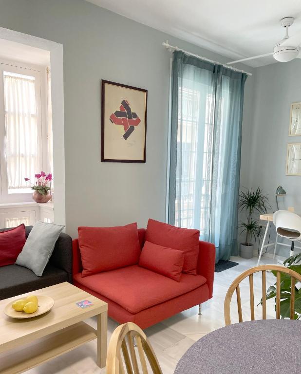 Hotel Elegancia y confort en el corazón de Málaga, a living room with a red couch and a table at Elegancia y confort en el corazón de Málaga in Málaga