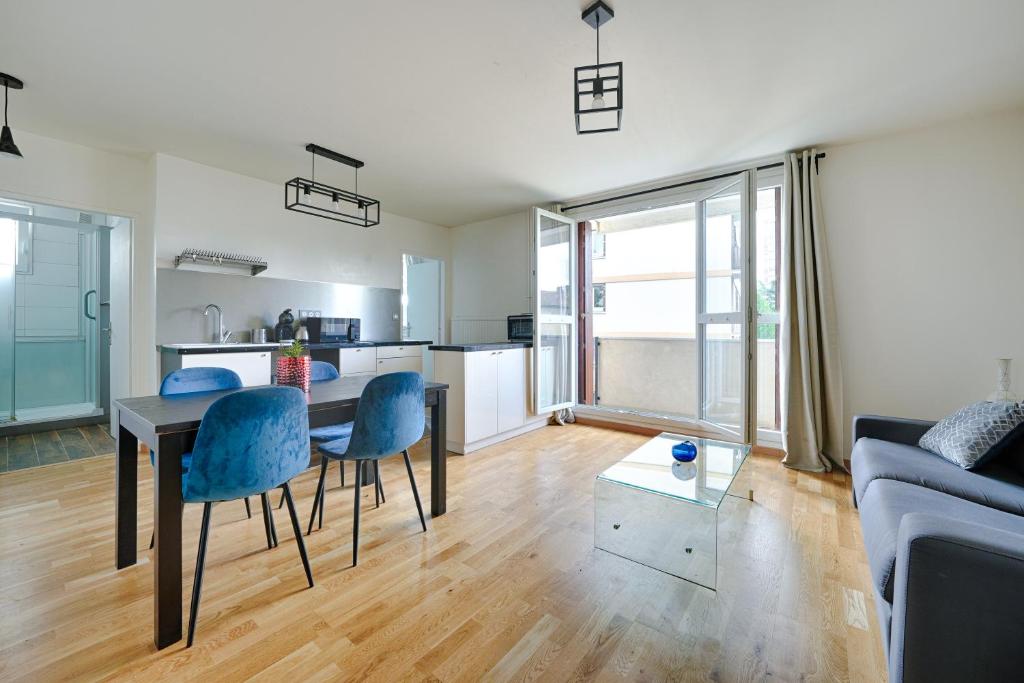 un salon avec une table et des chaises et une cuisine dans l'établissement Michelet, à Ivry-sur-Seine