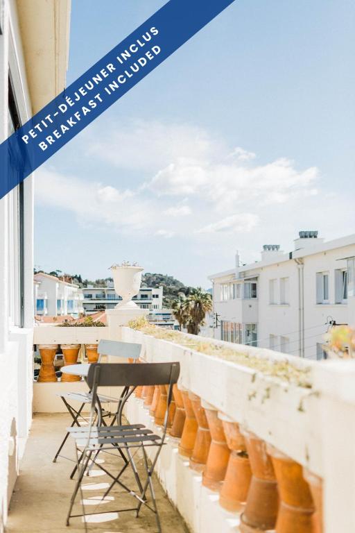 a balcony with chairs and a view of the city at Hôtel Les Voiles in Toulon