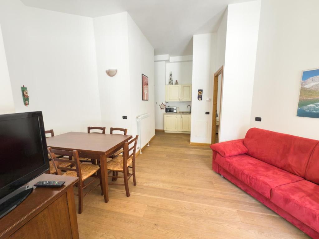 a living room with a red couch and a table at Bilocale sulle piste da sci in Pila