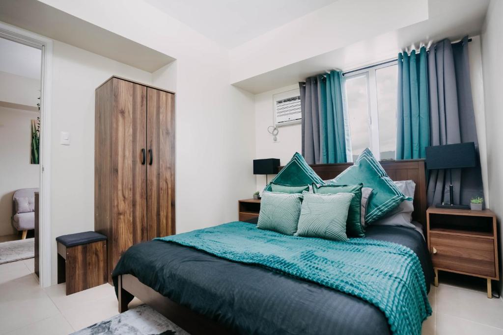 a bedroom with a bed with a blue comforter at NEW Elegant 1BR Condo Cebu IT Park Hotspot in Cebu City