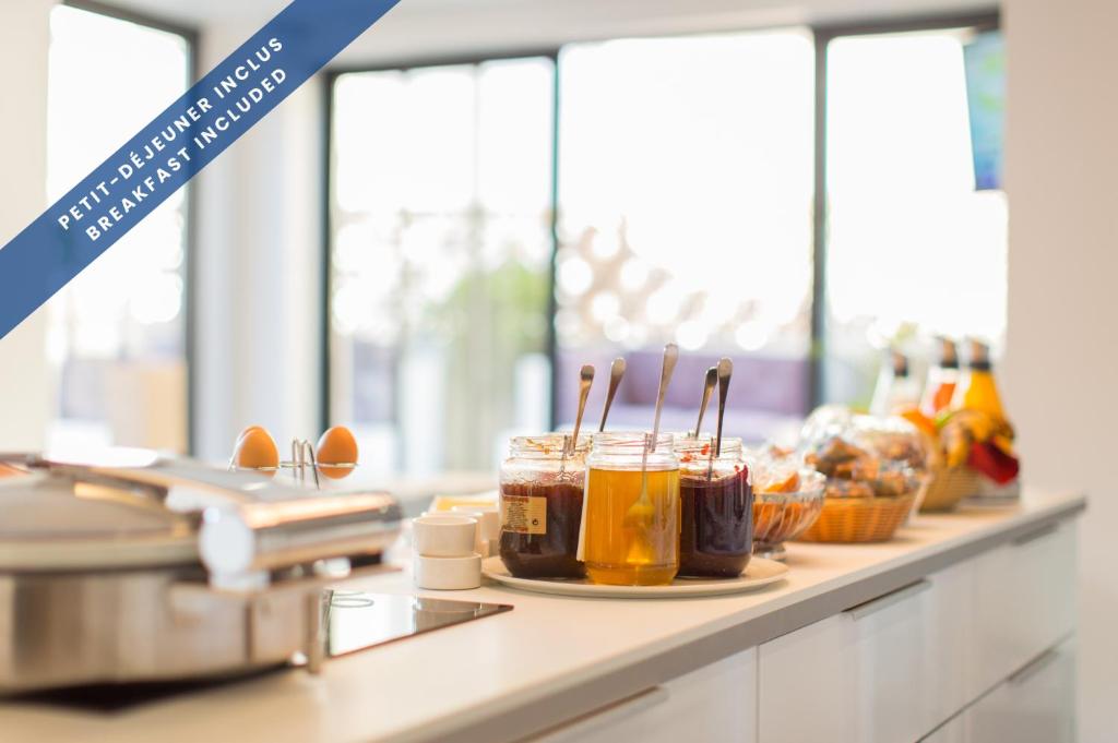 a kitchen counter with jars of honey on it at Hôtel Les Voiles in Toulon