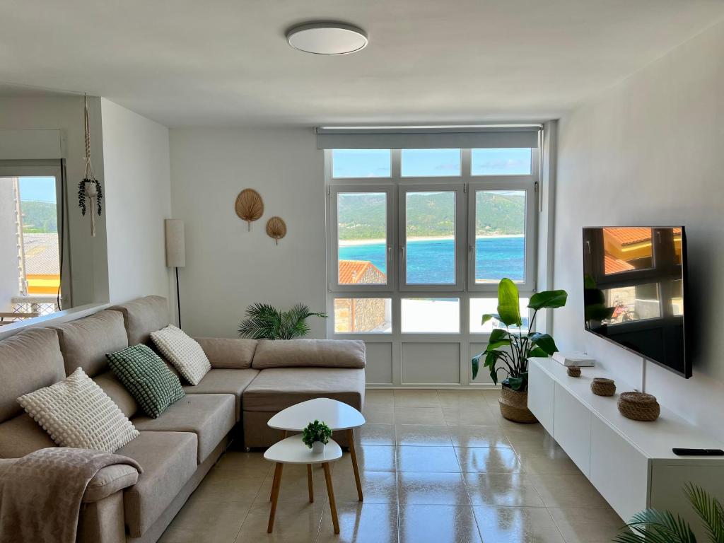 a living room with a couch and a tv at Apartamento SOLPOR in Finisterre
