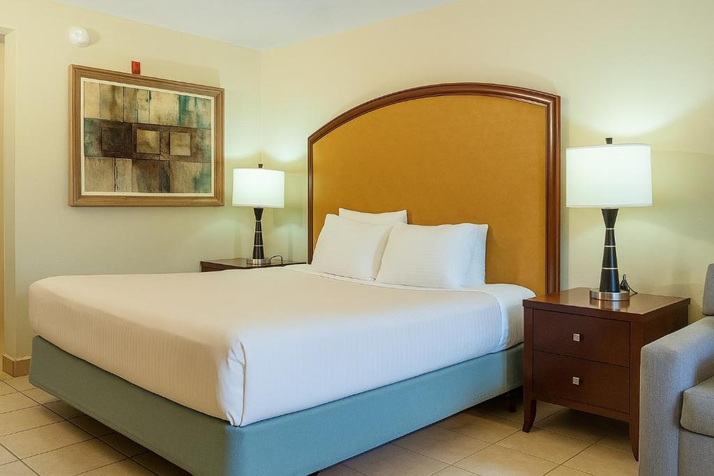 1 dormitorio con 1 cama grande con 2 lámparas y 1 sofá en Serena Inn, en Kissimmee