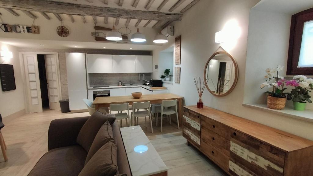 Una cocina y una sala de estar con un sofá y una mesa. en Porta Fiorentina Home, en Castiglion Fiorentino