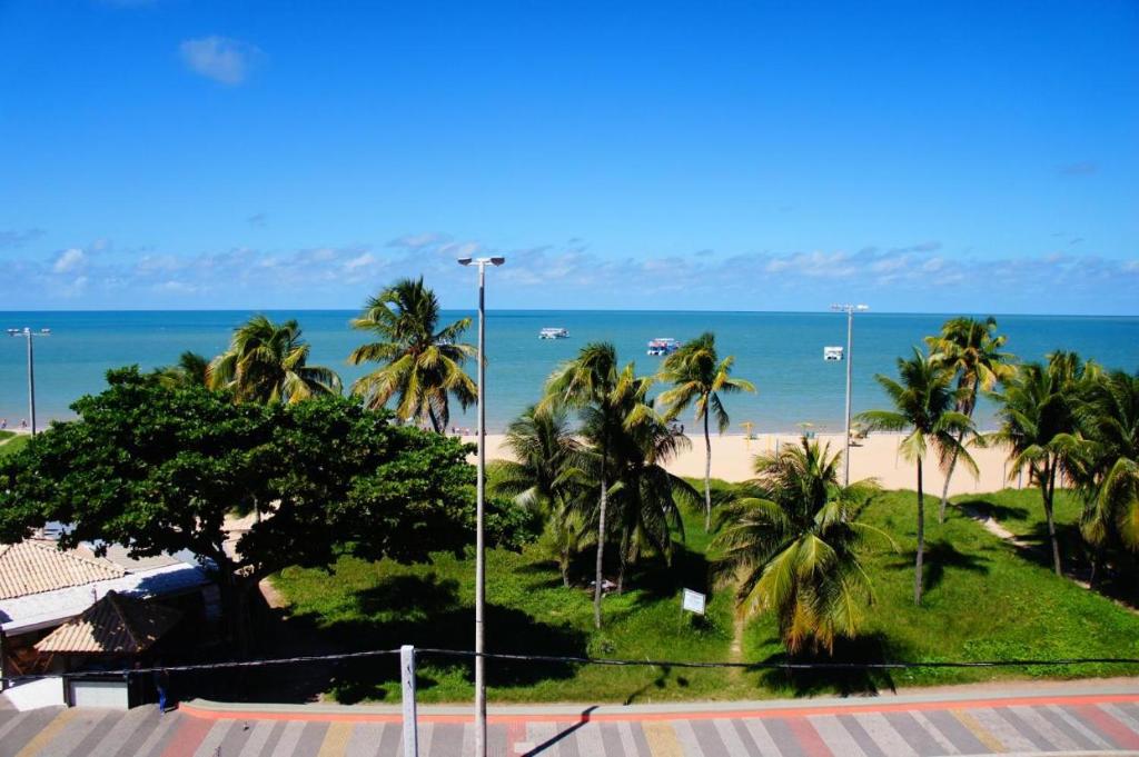 a view of a beach with palm trees and the ocean at Imperial Flat 111 Beira Mar Tambaú in João Pessoa
