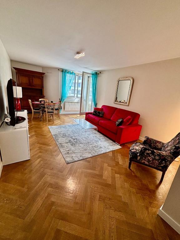 un salon avec un canapé rouge et une table dans l'établissement 2 chambres, garage voiture, résidence calme, à Villeurbanne