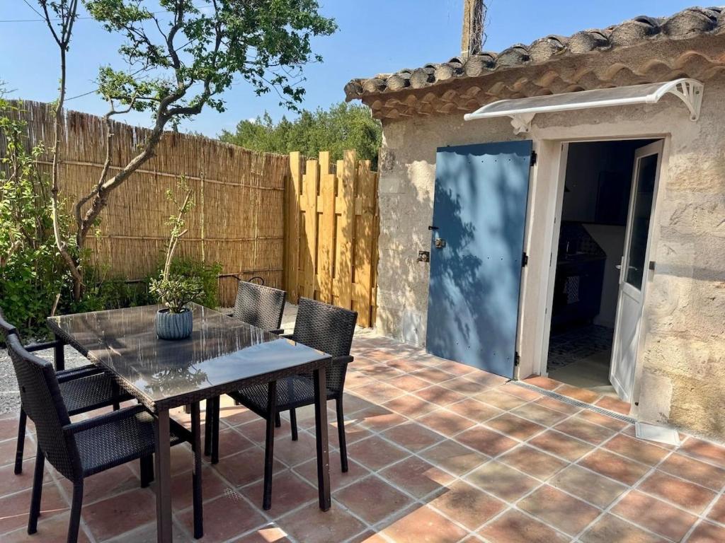 un patio avec une table et des chaises et une clôture dans l'établissement Maset Lou Pitchoun, à Saint-Rémy-de-Provence