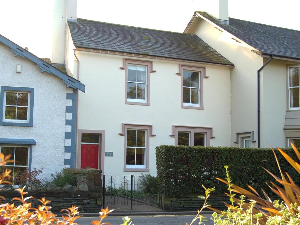 a white house with a red door at Shorley Lodge in Keswick