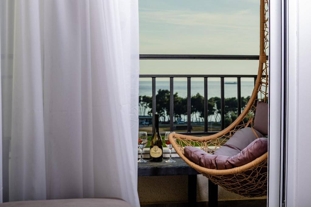 a balcony with a hammock and a table with wine glasses at Alpha Neo in Bar