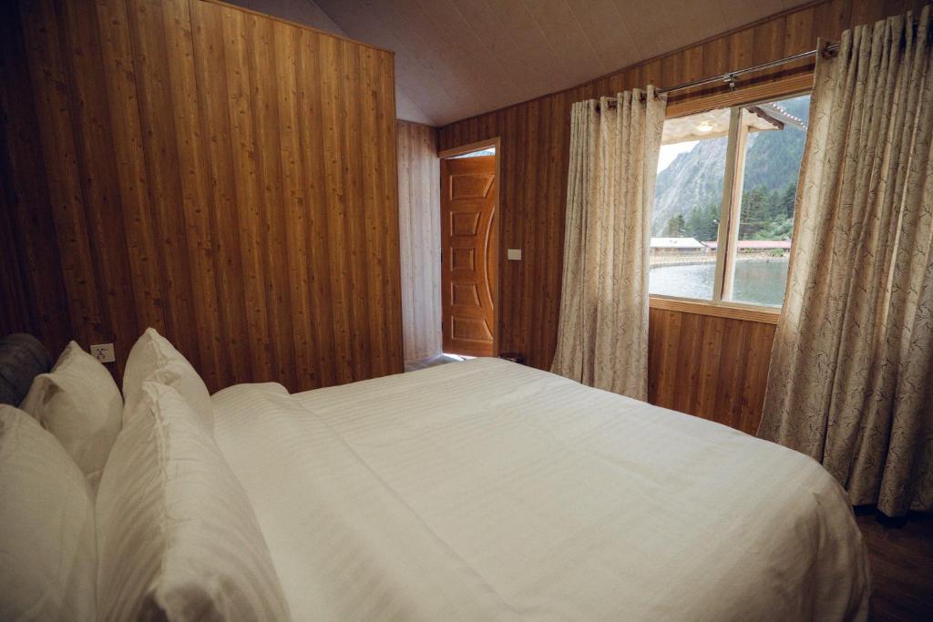 a bedroom with a large white bed with a window at Azure Lagoon Resort 