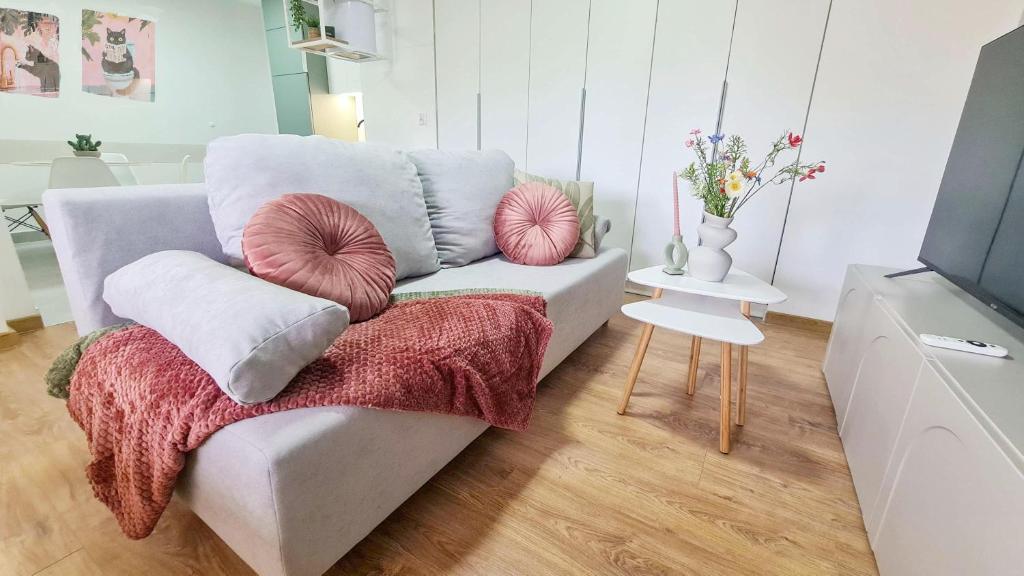 a living room with a couch with pillows on it at Apartament 3A na ul Wiejskiej 32c in Oświęcim